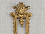 an image of a gold mirror with a flower decoration on it