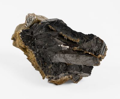 a close up of a piece of black rock on a white surface