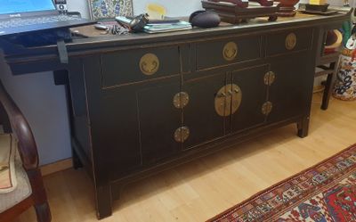 un ordinateur portable posé sur une commode dans un salon