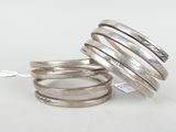 three silver rings stacked on top of each other on a white surface