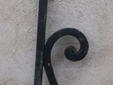 a black iron scroll on the side of a building
