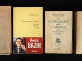 several old books are lined up on a black surface