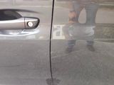 a reflection of a person in the door of a car