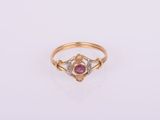 gros plan d'une bague en or avec une pierre rose