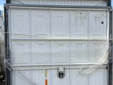 a large white garage door on a truck in a parking lot