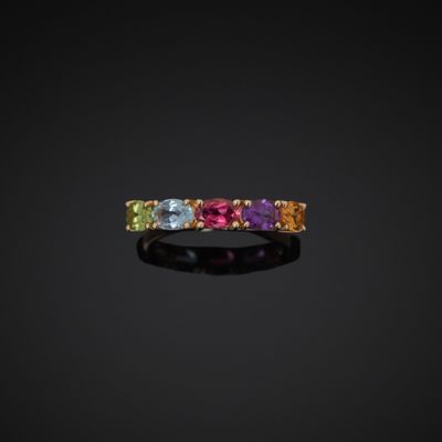 a multicolored sapphire and diamond ring on a black background