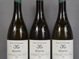 three bottles of wine are lined up on a table