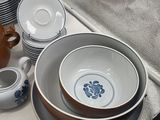 a lot of dishes and cups sitting on a table