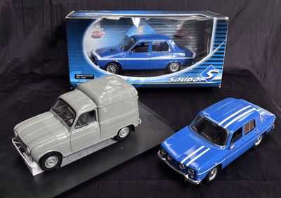 two toy cars sitting next to each other on a black surface