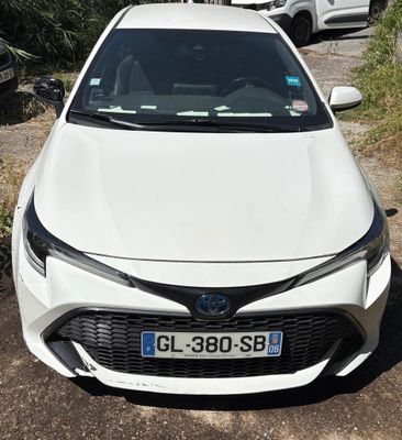 l'avant d'une Toyota Corolla blanche garée sur le bord de la route