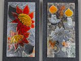 Deux tableaux accrochés au mur d'une pièce : l'un représente un vase et l'autre des fleurs.