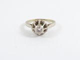 a close up of a diamond ring on a white surface