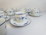 several cups and saucers are lined up on a white table