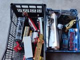 un panier rempli d'objets divers, posé par terre