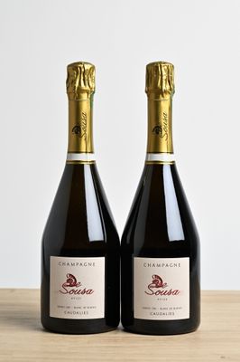 two bottles of wine sitting on top of a wooden table
