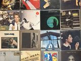 many different album covers on the wall of a room