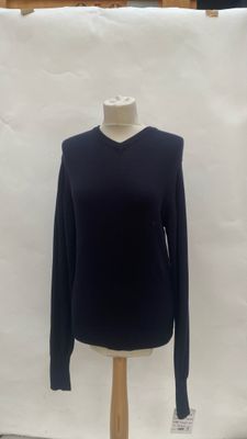 black sweater on a mannequin stand in front of a white backdrop