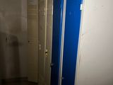 des toilettes au milieu d'une salle de bains aux portes bleues