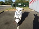 a white motorcycle parked in a parking lot next to a green fence