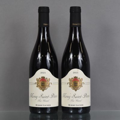 two bottles of wine sitting on top of a table next to each other