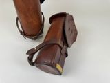 pair of brown leather boots with brown straps and a brown bag
