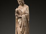 une statue représentant un homme en robe tenant un oiseau