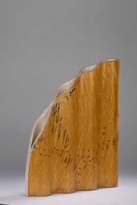 sculpture représentant un serre-livres en bois posé sur une surface blanche, avec un fond gris