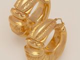 two gold hoop earrings on a white background