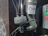a blender with a whisk on it next to a cup of coffee