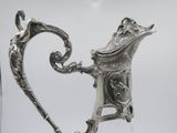 a silver pitcher that is sitting on a table