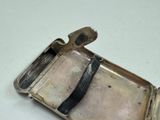 a small silver case with a black ribbon on it