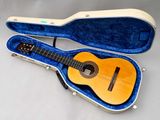 une photo d'une guitare dans son étui, posée sur une table