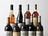 plusieurs bouteilles de vin sont alignées sur une table en bois