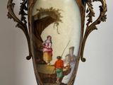 un vase avec un tableau posé sur une table