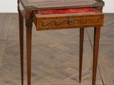 a small wooden table with a red tray on it