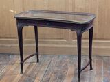 a small table with a glass top sitting on a wooden floor