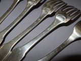 five forks and two spoons on a table