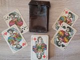 quatre cartes à jouer et un portefeuille posés sur une table en bois