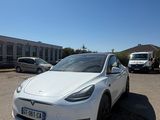a white tesla car parked in a parking lot