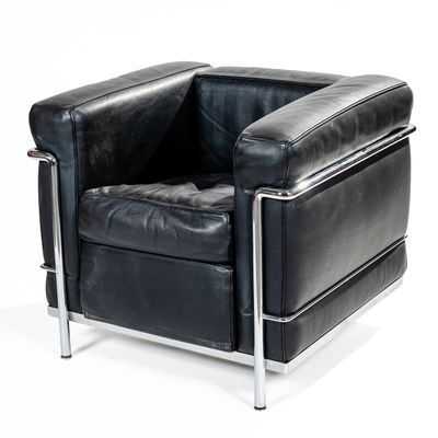 black leather chair with chrome legs and arm rests against a white background