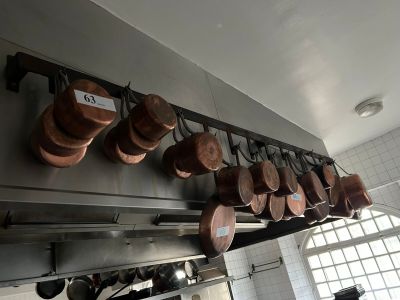 pots and pans hanging from the ceiling of a kitchen