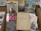 several books are stacked on top of each other in a box