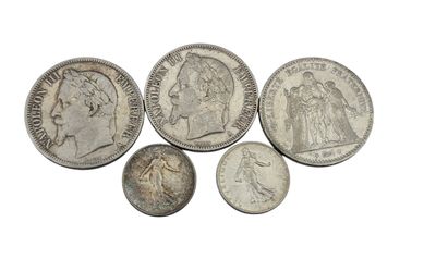 a group of silver coins sitting on top of a white surface