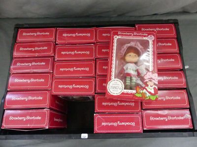 une boîte de petits gâteaux aux fraises contenant une poupée