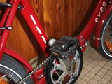 a red bicycle parked in a room with a wooden wall