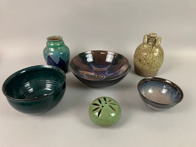 de nombreux bols et vases de toutes sortes posés sur une table