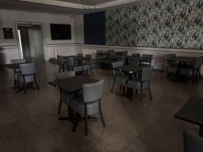 de nombreuses tables et chaises dans une pièce dont l'un des murs est tapissé