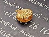 une image représentant un coquillage doré posé sur une plaque