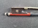 a wooden bow with a red handle on a black surface