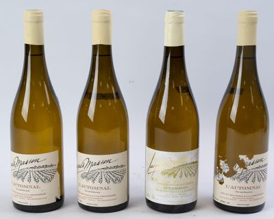 quatre bouteilles de vin sont alignées sur une surface blanche
